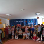 Zbiorowe zdjęcie gości na tle dekoracji julileusz przedszkola 50 lat