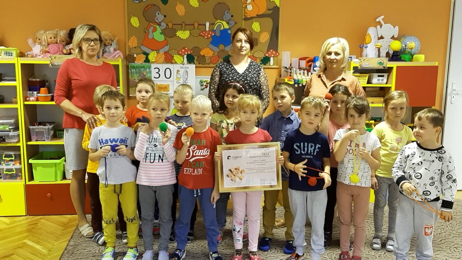 Grupa dzieci z nauczycielkami, prezentująca Certyfikat Grupy Froeblowskiej