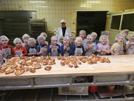 Zdjęcie grupowe dzieci w piekarni z prowadzącą warsztaty.jpg