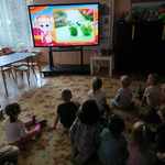 dzieci oglądają na tablicy multimedialnej prezentację o warzywach