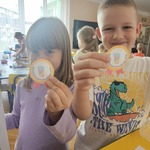 Chłopiec i dziewczynka pokazują otrzymane medale.jpg