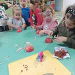 dzieci tworzą jeże z jabłek