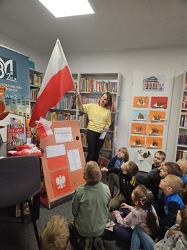 Pani prezentuje dzieciom flagę Polski.jpg