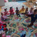 dzieci siedzą w kole na dywanie