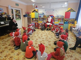 Dzieci siedzą w kole przy Mikołaju.jpg