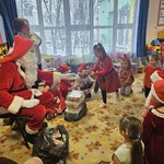 Mikołaj rozdaje dzieciom prezenty.jpg