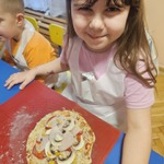 Dziewczynka prezentuje swoją pizzę.jpg