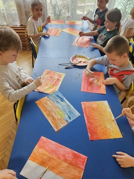Dzieci malują farbami przy stolikach.jpg