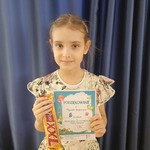 Dziewczynka trzyma dyplom za udział w konkursie.jpg