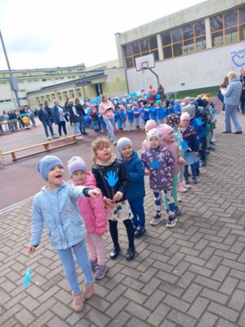 Przedszkolaki uczestniczą w "niebieskim marszu" na rzecz osób z autyzmem.