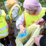 Dzieci wkładają śmiecie do plastikowych worków.