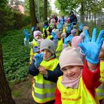 Dzieci włożyły gumowe rękawiczki i przygotowują się do sprzątania lasu.