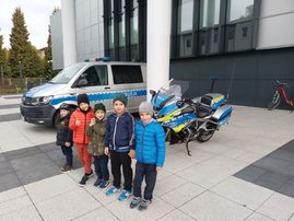 zdjęcie 5 chłopców przed radiowozem policyjnym