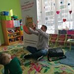 Pan Łukasz pokazuje dzieciom książkę Basia.